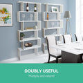 Two white S-shaped bookcases in dining room beside white dining table, text reads Doubly Useful