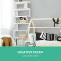 White S-shaped bookcase in children's bedroom beside house-frame bed, text reads Creative Decor