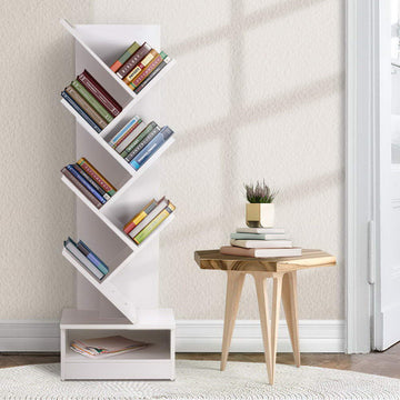 White 7-tier tree-shaped bookcase filled with colourful books beside small wooden side table in bright room