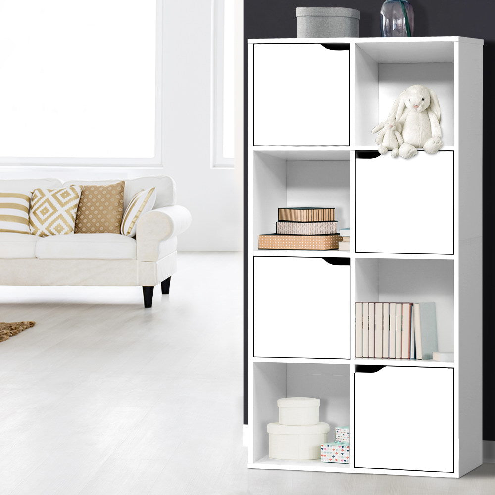 White 8-cube storage shelf in living room styled with stuffed rabbit, books and storage boxes against dark wall