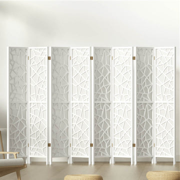 White 8-panel MDF room divider with geometric star pattern cutouts in lifestyle room with chair and ottomans