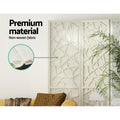 White 8-panel geometric MDF room divider non-woven fabric panel close-up in lifestyle room with palm plant and yellow sofa