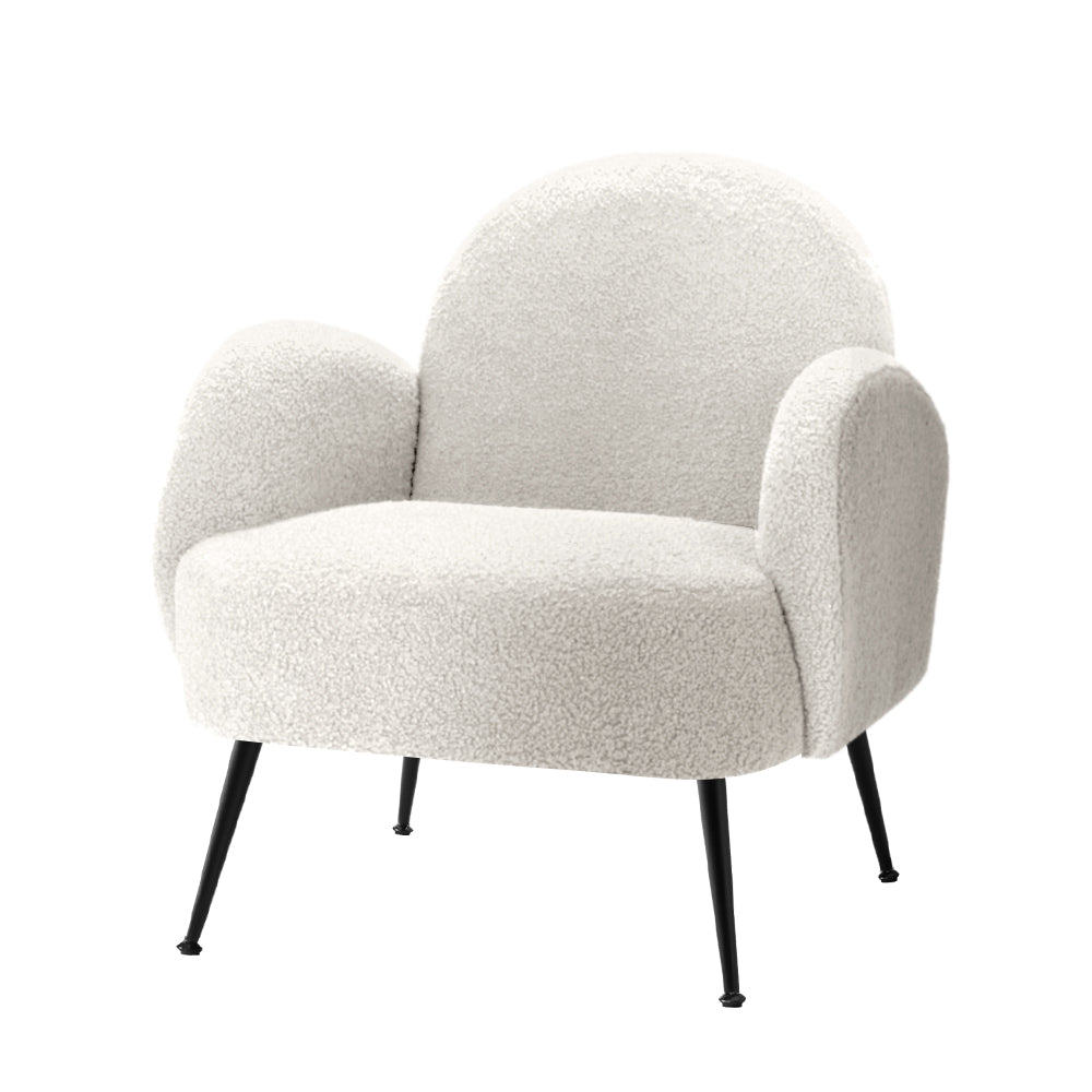 White boucle armchair with rounded arch back, curved armrests and black metal splayed legs, angle view on white background