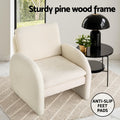 White boucle arch armchair on rug with black side table, 