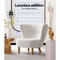 White boucle button-tufted wingback chair with wood legs in styled room, 