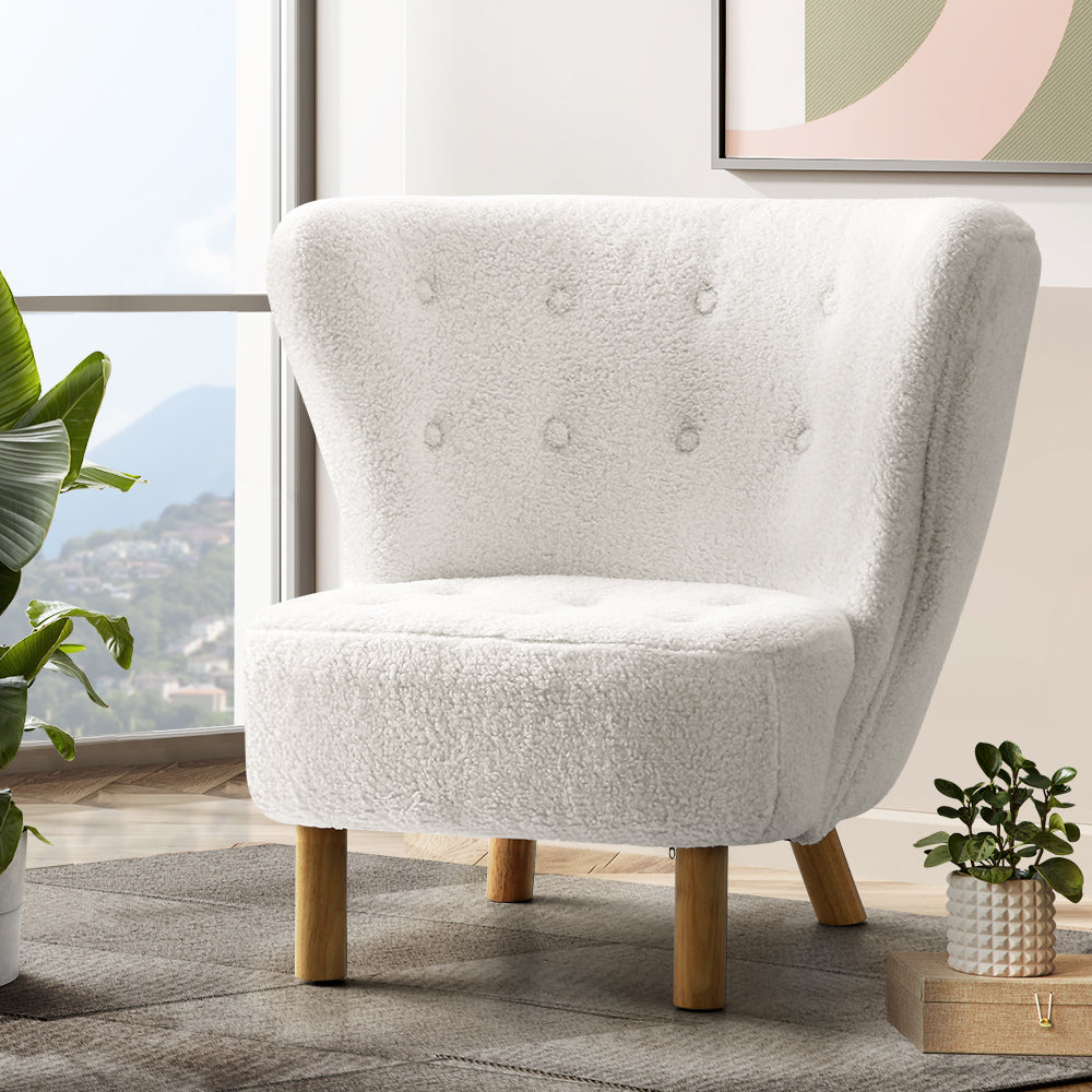 White boucle button-tufted wingback accent chair with natural wood cylindrical legs in living room near window