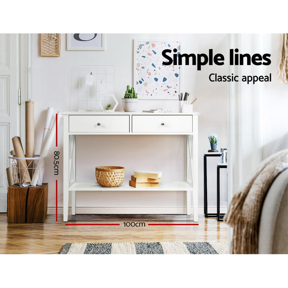 White console table with X-frame sides in room; dimensions 100x80.5cm, styled with cactus and books; text "Simple lines"