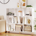 White low cube bookshelf with nine open compartments on angled wood legs, styled with books and baskets in living room