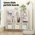 White cube bookshelf styled with figurines, books and baskets in room, text reads 12mm thick particle boards