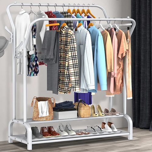 White double-rail garment rack angled view loaded with clothes bags and shoes in bedroom setting