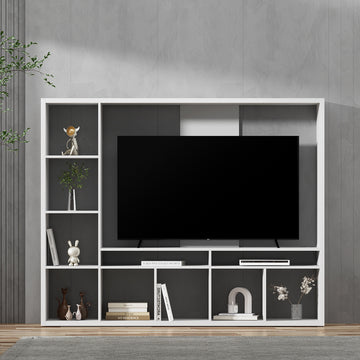 White large entertainment wall unit with TV mounted above showing open shelves with books and decor