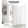 White fabric grid room divider 178.5cm height infographic in lifestyle room with framed wall photos and orchid plant