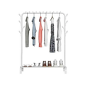 White garment rack on white background loaded with dark and patterned clothes with sneakers and shoes on bottom shelf