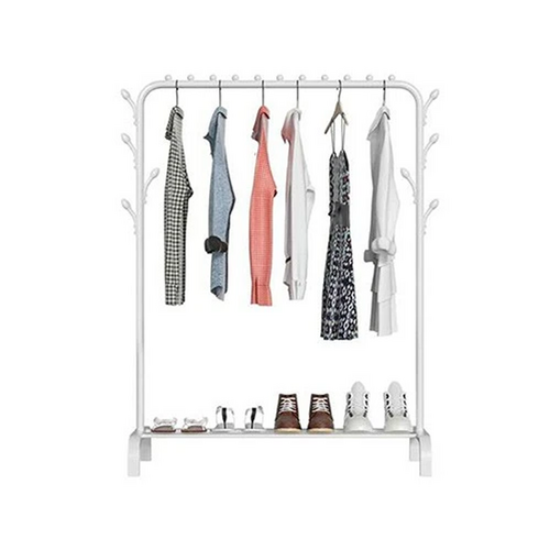White garment rack on white background loaded with dark and patterned clothes with sneakers and shoes on bottom shelf