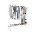 White garment rack on white background loaded with light summer clothes in blue and grey tones with shoes and basket