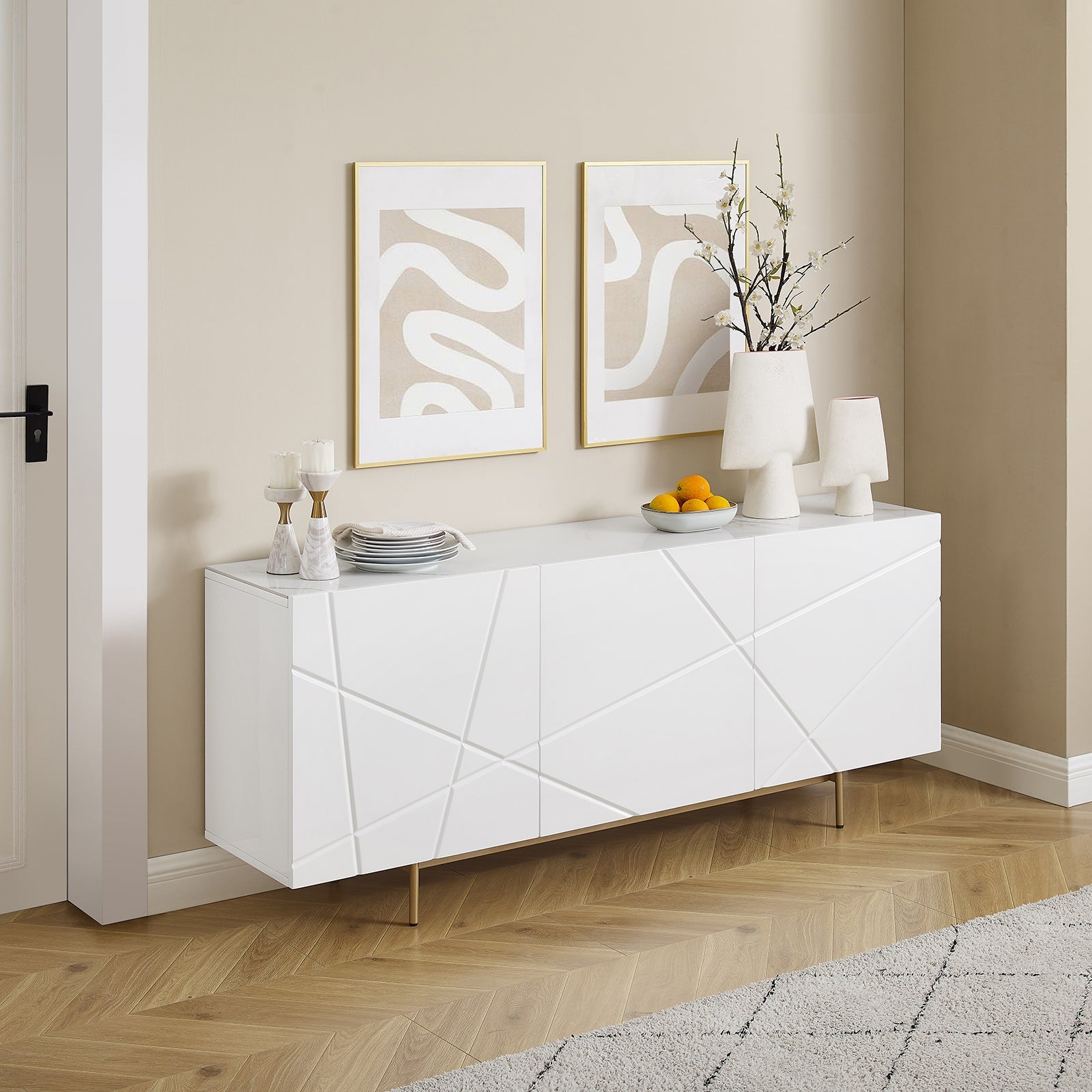 White gloss buffet with geometric line doors and gold hairpin legs in room, abstract art and cherry blossom vase on top