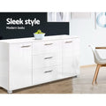 White gloss buffet in dining area with dark wall, fruit bowl on top, white chair beside; text: sleek style, modern looks