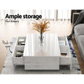 White gloss coffee table with four push-to-open drawers all open showing storage in living room