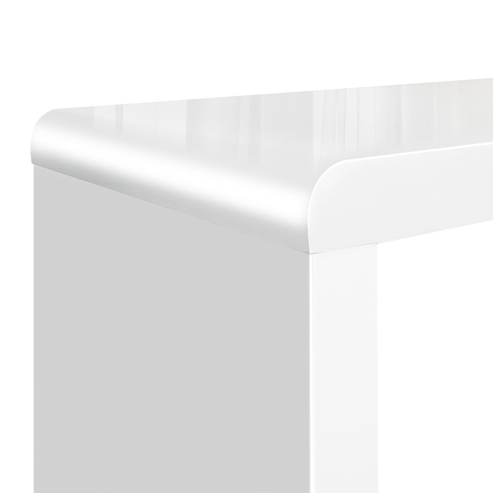Close-up of rounded corner on white high-gloss nesting table top with reflective surface on white background