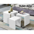 Three white gloss nesting tables beside a grey sofa on a patterned rug, text reads Stylish decor Pleasing aesthetics