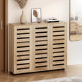 White hall tree entryway unit with coat hooks holding scarves and jackets above open shoe cubbies