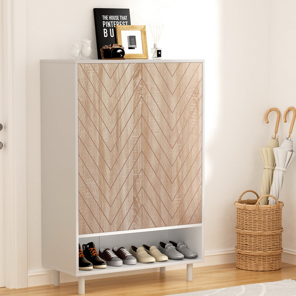 White shoe cabinet with herringbone oak doors and open bottom shelf in entryway with umbrella stand