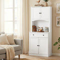 White two-piece hutch cabinet with arched niche styled with books and ceramics in a living room setting