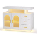 White LED sideboard with floating shelf, two arch fluted glass doors, three drawers with gold handles and LED base glow