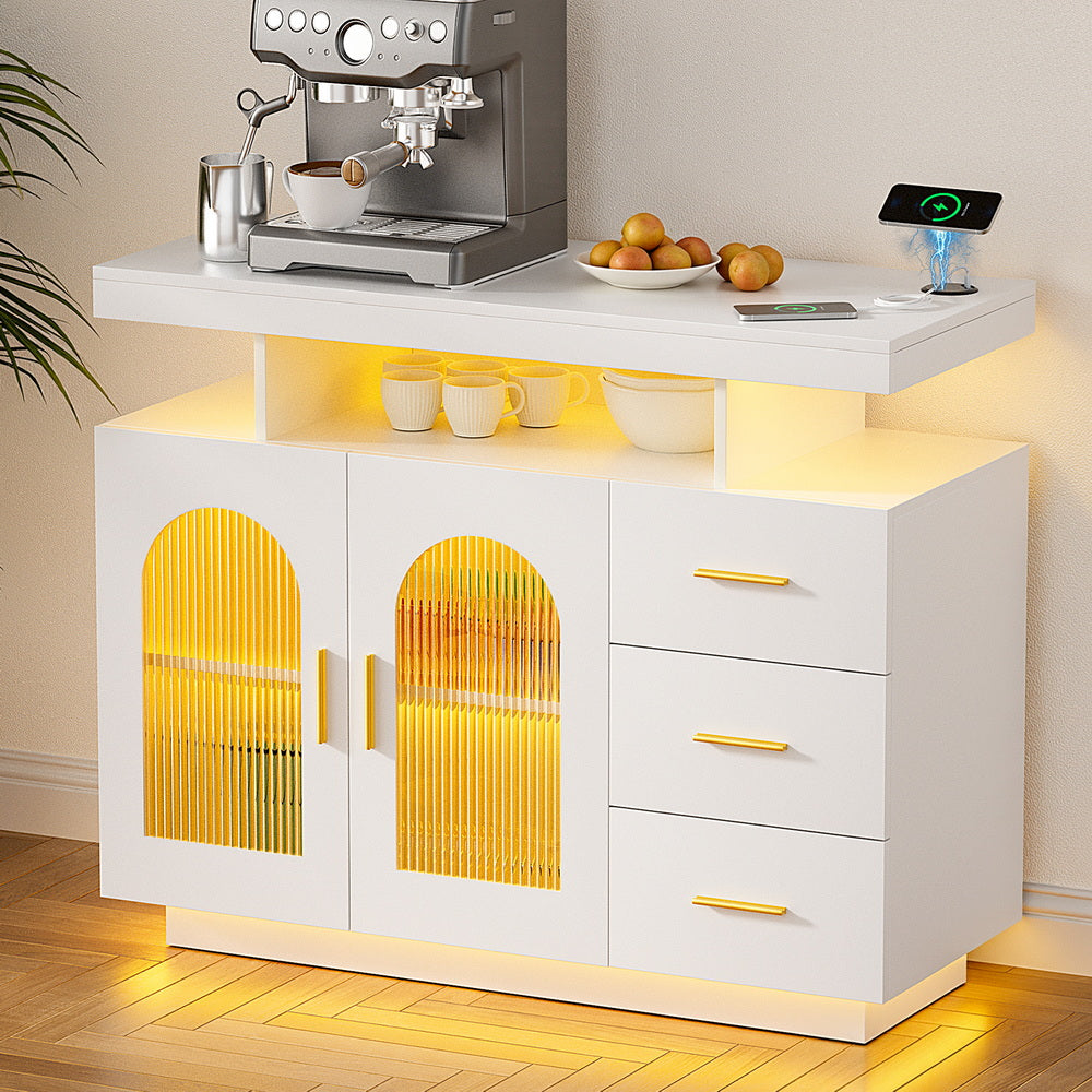 White LED arch sideboard in kitchen with gold LED glow, espresso machine and fruit on top, mugs on open shelf, phone charging