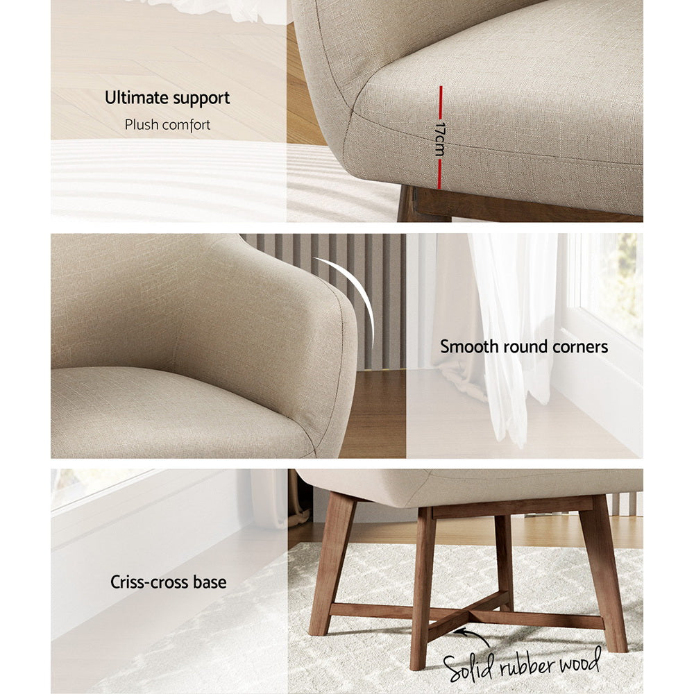 White linen barrel armchair beside pedestal side table with flowers, rustic concrete wall and wooden floor background