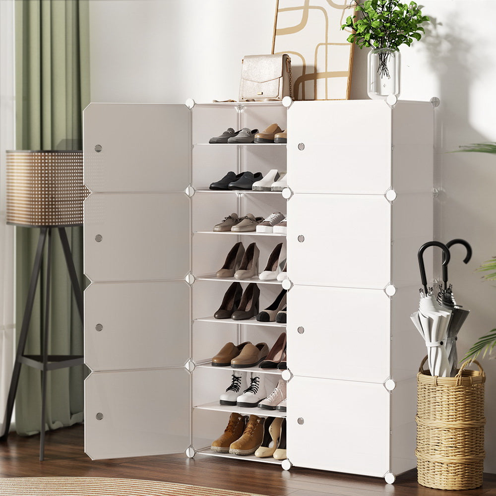 White modular cube shoe cabinet in hallway with centre column open showing shoes lamp umbrella stand and plant