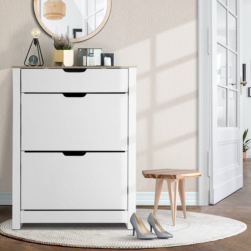 White shoe cabinet with oak top three flip-out doors in hallway with round mirror plant lamp and silver heels on rug