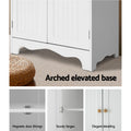White pantry cabinet features: arched scalloped base, magnetic door fittings, sturdy hinges, round wood knob detail