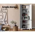 White tall pantry cabinet with all doors open showing 6-tier shelving with books and decor in room; text: ample storage