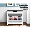 White shoe bench with black cushion and trays deployed holding three pairs of heels in entry with text clutter-free entrance