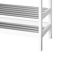 Close-up of two stainless steel slatted shelves on white bamboo shoe storage bench frame