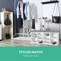 White shoe bench grey cushion with sneakers in boutique dressing room stylish match text garment racks crates and tall vase