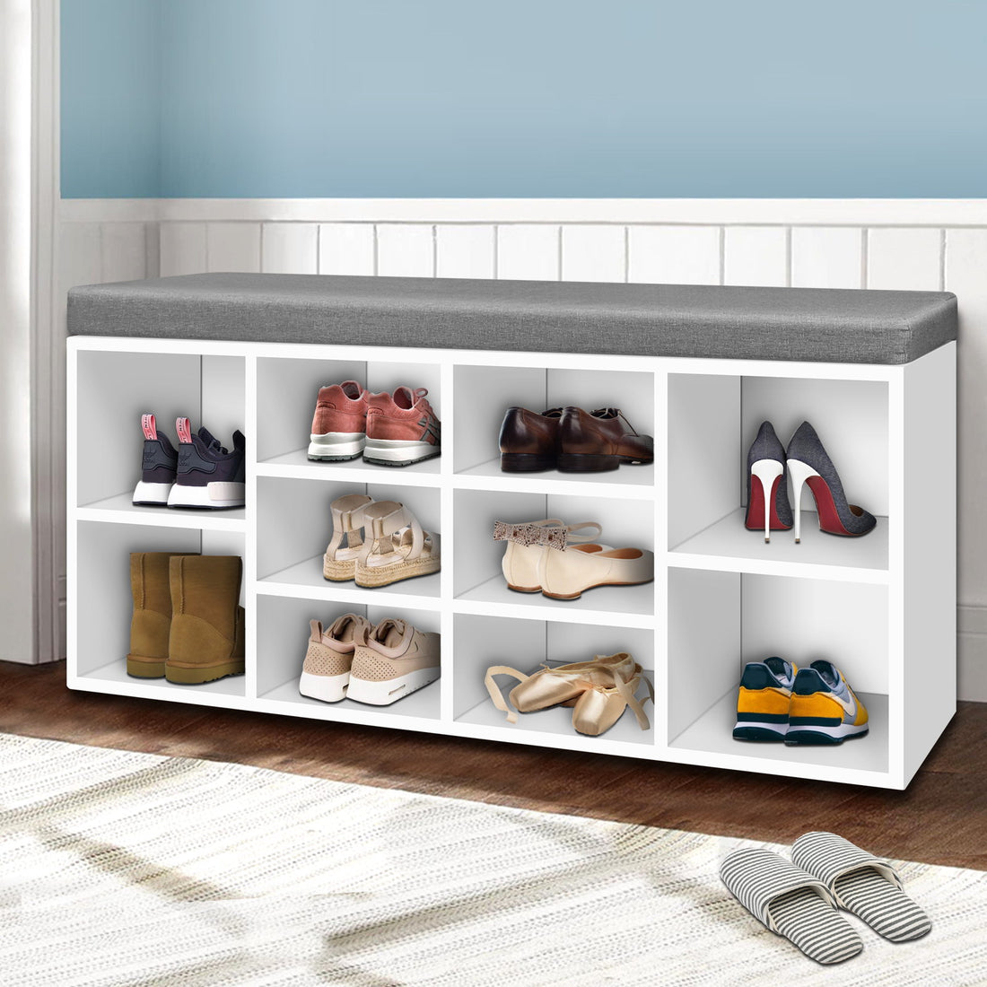 White shoe bench grey cushion with boots heels ballet flats and sneakers in hallway lifestyle with blue wall wainscot