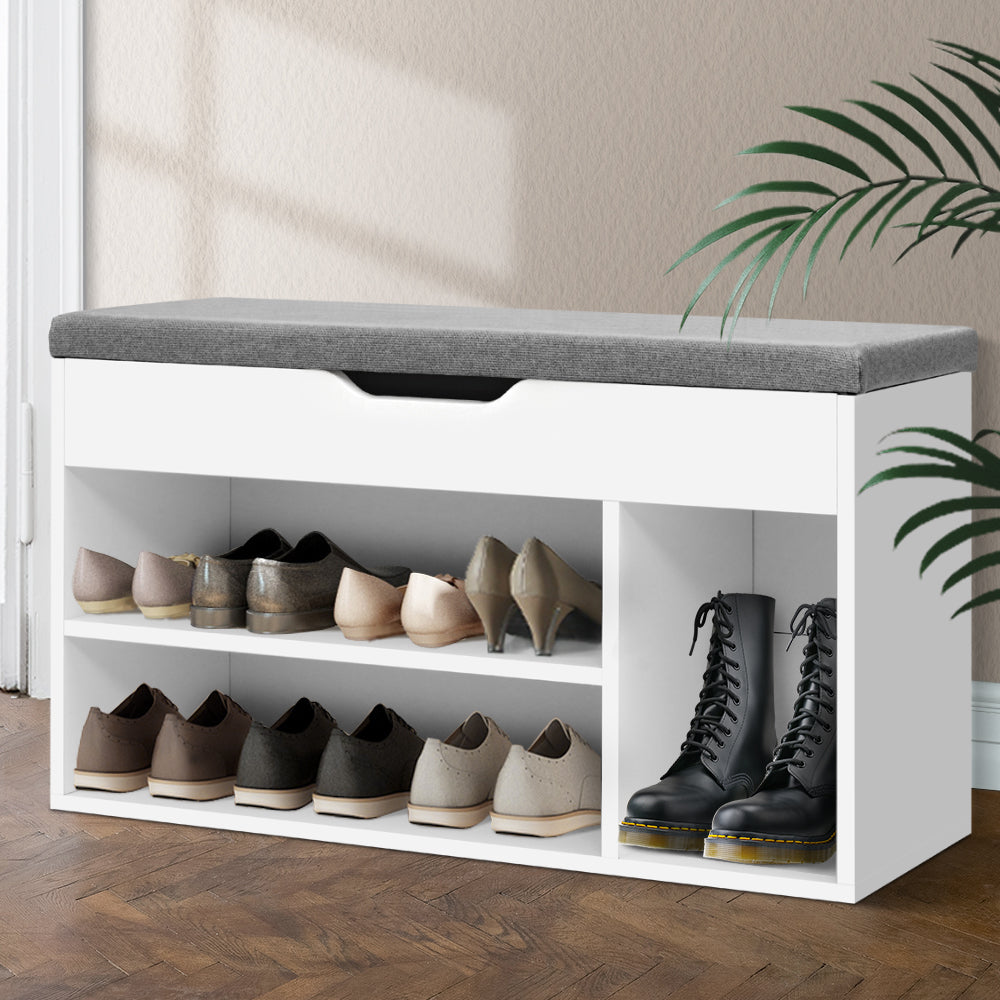 White shoe bench with grey cushion open lower shelves loaded with heels oxfords and tall boot nook on herringbone floor