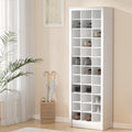 White open-slot shoe cabinet in hallway with peach walls, umbrella stand and plant beside