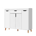 White shoe cabinet three-quarter view top drawer black air gap handles three lower hinged doors on natural wood cone legs