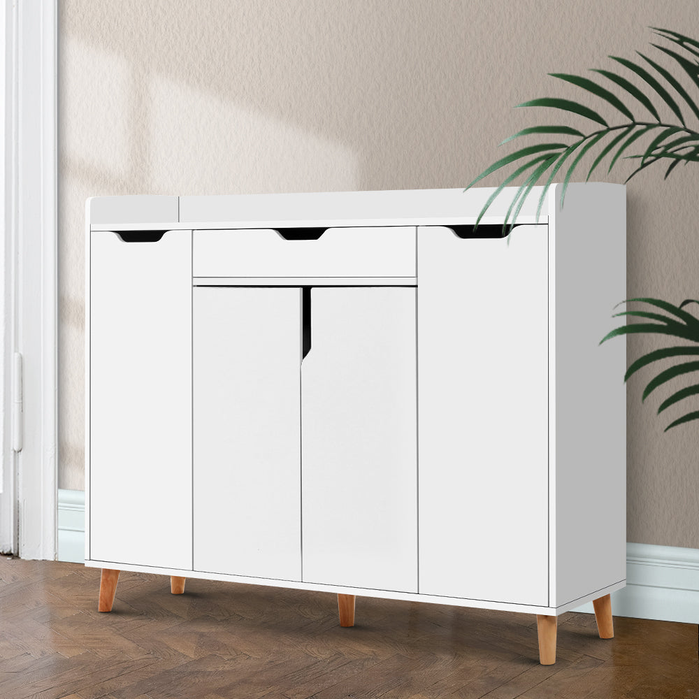White shoe cabinet with top drawer three lower hinged doors and natural wood cone legs in hallway with herringbone floor