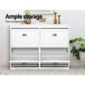 White shoe cabinet with two upper flip-out trays open and two lower doors closed in lifestyle setting with ample storage text
