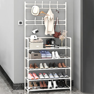 White shoe and hat stand fully loaded with shoes clothes hat bag and camera in grey entryway with marble floor