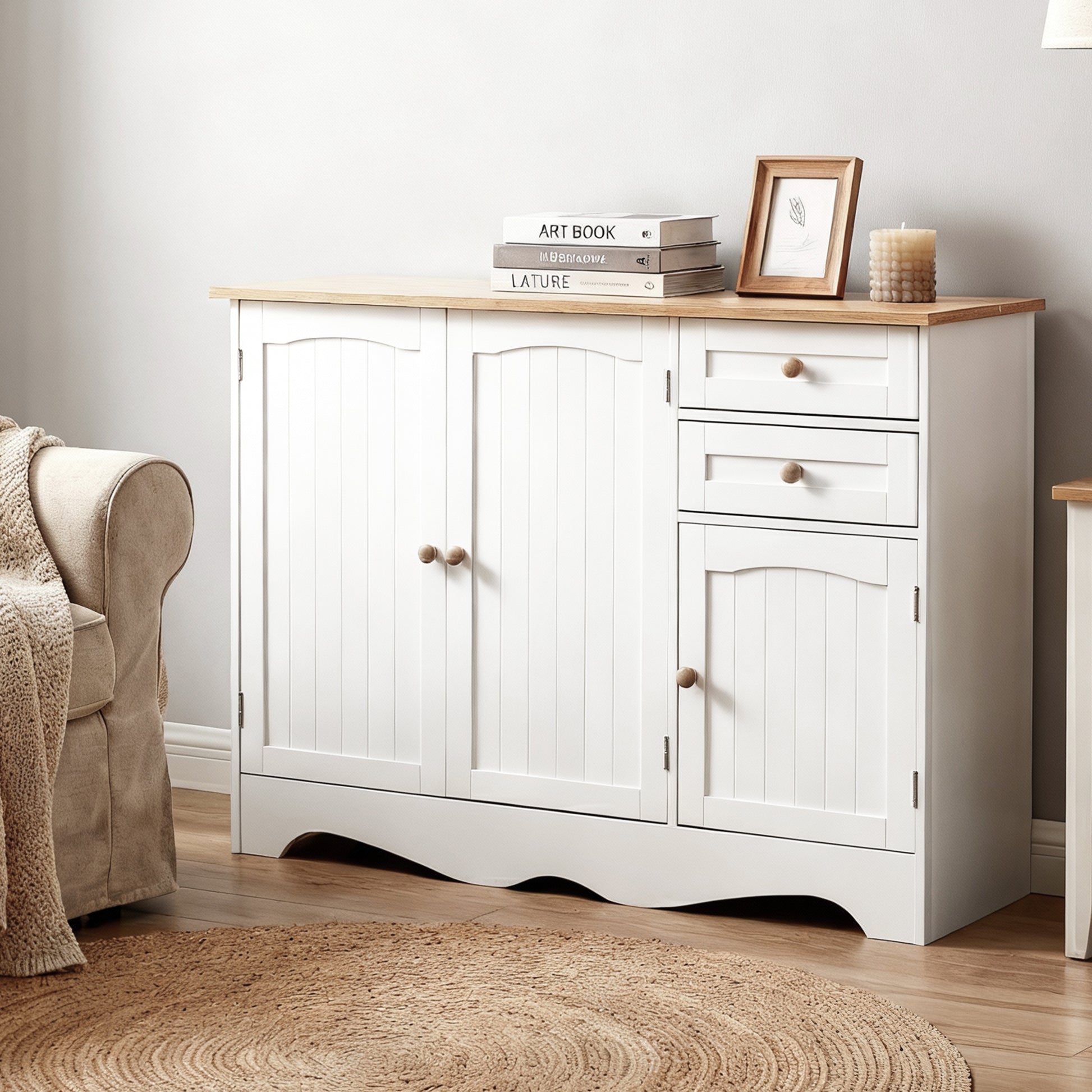 White sideboard with two doors, two drawers and one cabinet in living room, top styled with books, framed print and candle