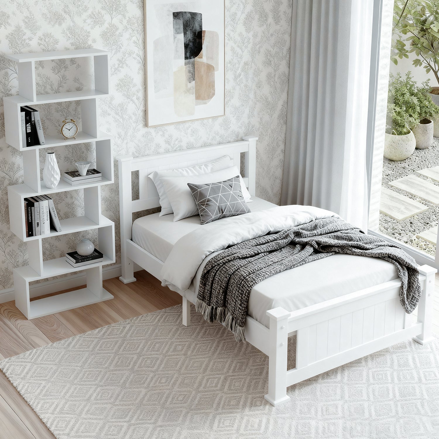 White single bed frame with panel headboard in bright bedroom with stair-step bookshelf and garden view through window