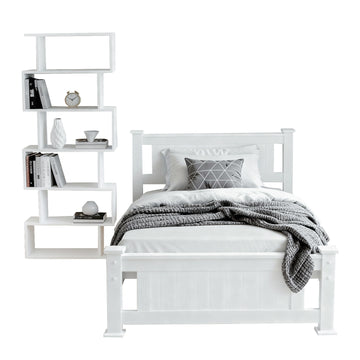 White single bed frame with panel headboard and footboard beside white zigzag bookshelf, on white background