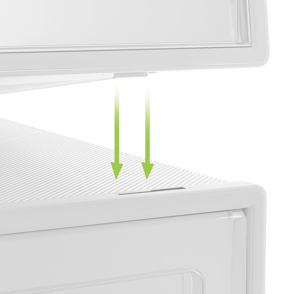 Close-up of white stackable shoe boxes showing stacking mechanism with green arrow indicators