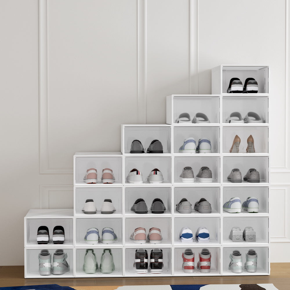 White clear-front stackable shoe boxes 24-pack arranged in staircase pattern loaded with shoes against molding wall