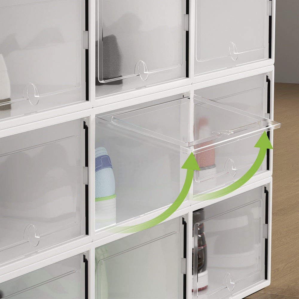Stack of 12 white shoe storage boxes with one front door open showing drop-front mechanism with green arrows